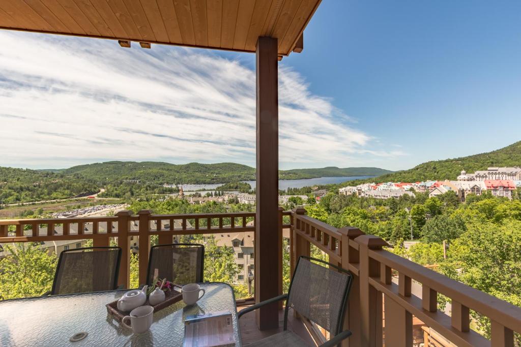 a view from the balcony of a house with a table and chairs at L'Altitude by Rendez-Vous Mont-Tremblant in Mont-Tremblant