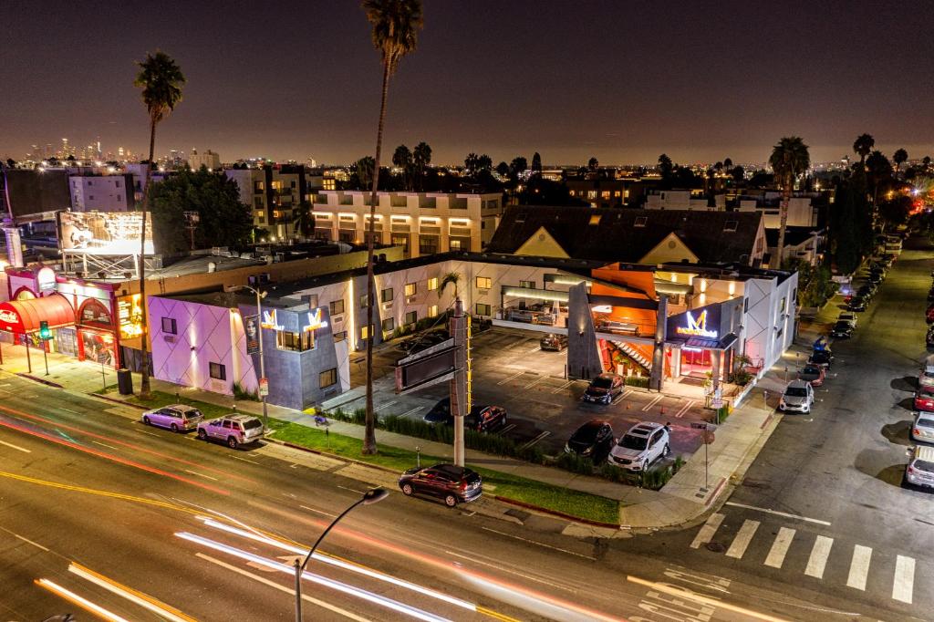Una ciudad de noche con coches aparcados en una calle en The Moment Hotel, en Los Ángeles