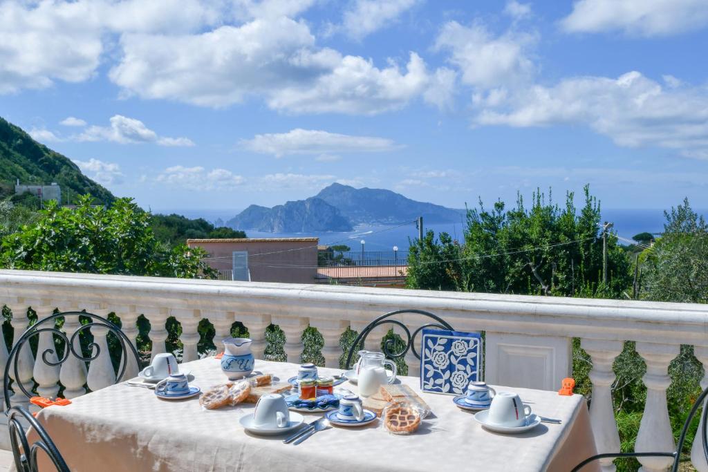 a table on a balcony with a view of the ocean at Il Profumo di Capri in Massa Lubrense
