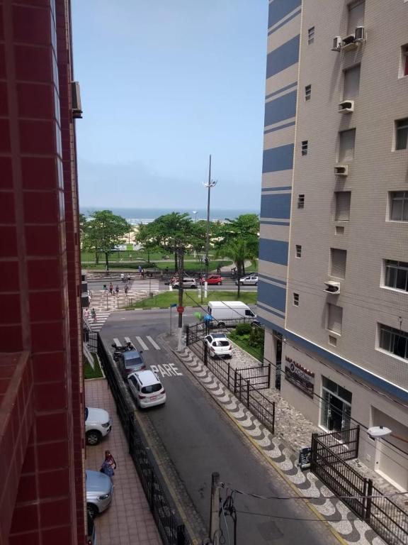 ulica miejska z samochodami zaparkowanymi obok budynku w obiekcie APARTAMENTO FRENTE AO MAR EM SANTOS w mieście Santos