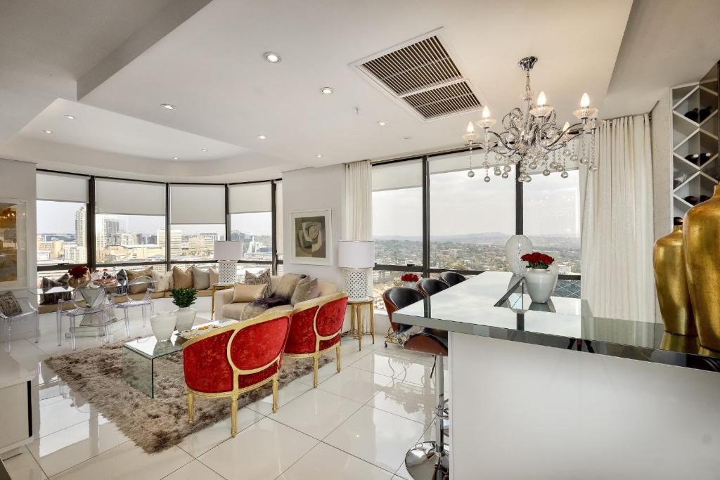 comedor y sala de estar con lámpara de araña en Sandton Skye Premium Suites & Penthouses, en Johannesburgo