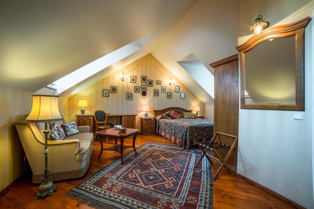 Shakespeare Boutique Hotel — Attic double room with sloped ceiling, skylight, wooden floors, bedside lamps, sofa, wall gallery and luggage rack