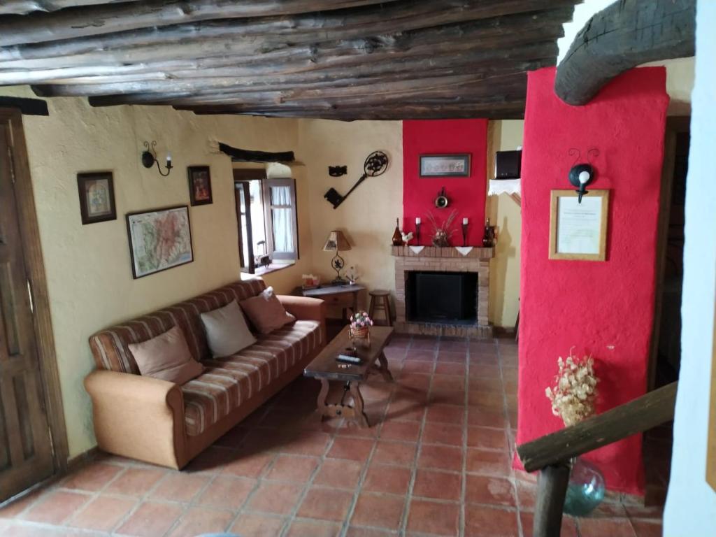 sala de estar con sofá y chimenea en Casa Antoñita, en Parauta