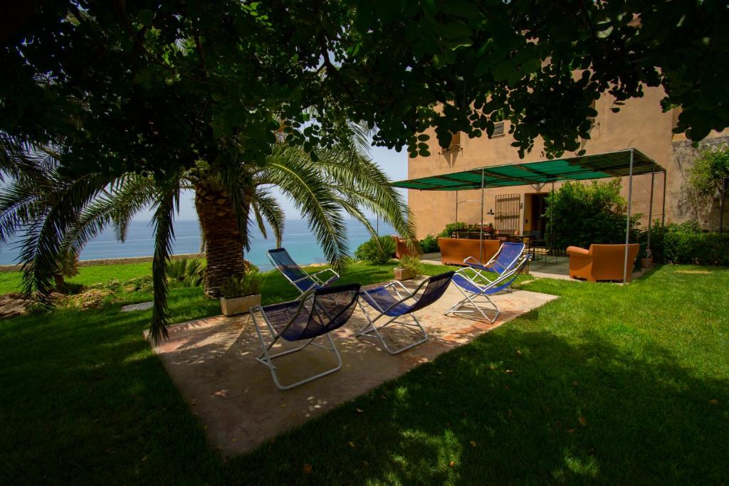 a group of chairs and a table under a tree at Maragani Beach in Maragani