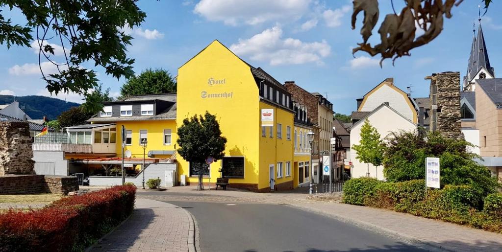 ein gelbes Haus an der Seite einer Straße in der Unterkunft Hotel Sonnenhof in Boppard