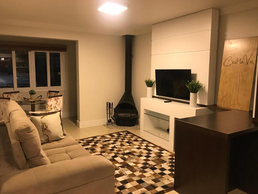 sala de estar con sofá y TV en Apartamento Baviera, en Canela