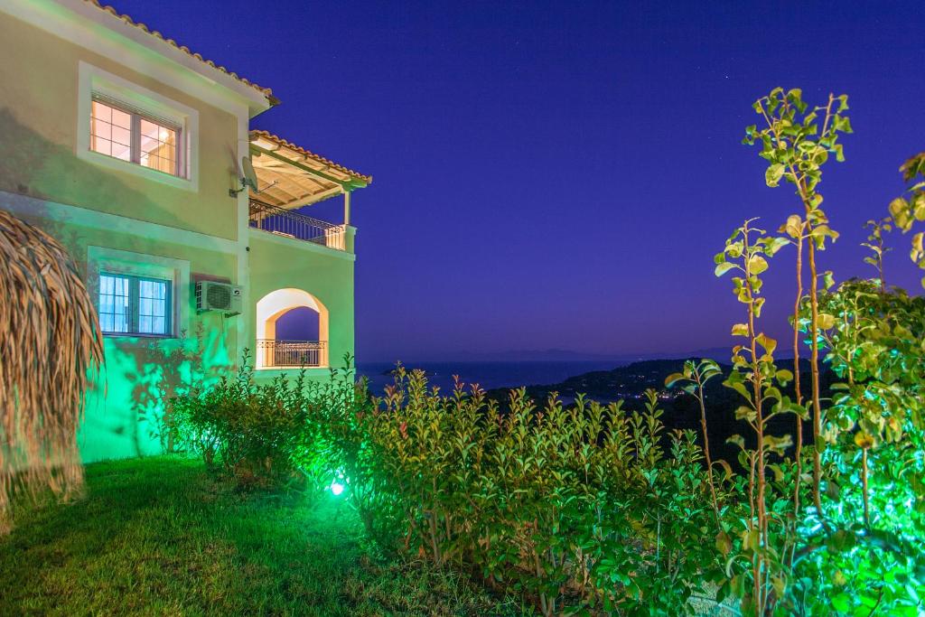 una casa con vistas al océano por la noche en Villa iliotropio en Skiathos