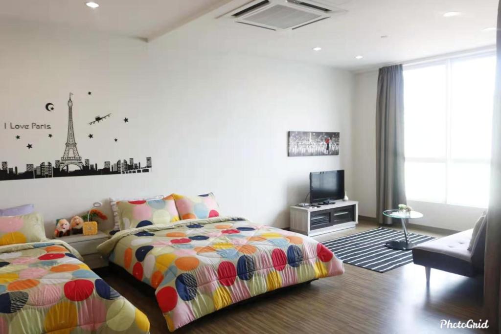 a bedroom with two beds and a tv in it at Setapak @ Zeta Suite in Kuala Lumpur