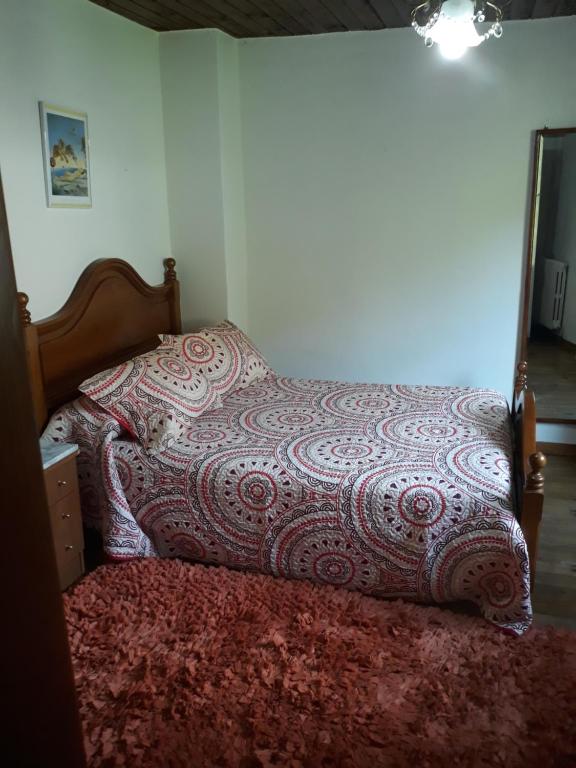 a bed with a blanket on top of it at Casa Da Carme in Casela