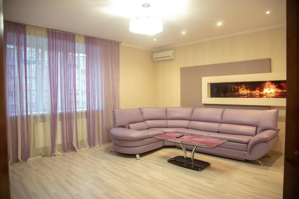 ein Wohnzimmer mit einem Sofa und einem Tisch in der Unterkunft Квартира Люкс in Winnyzja