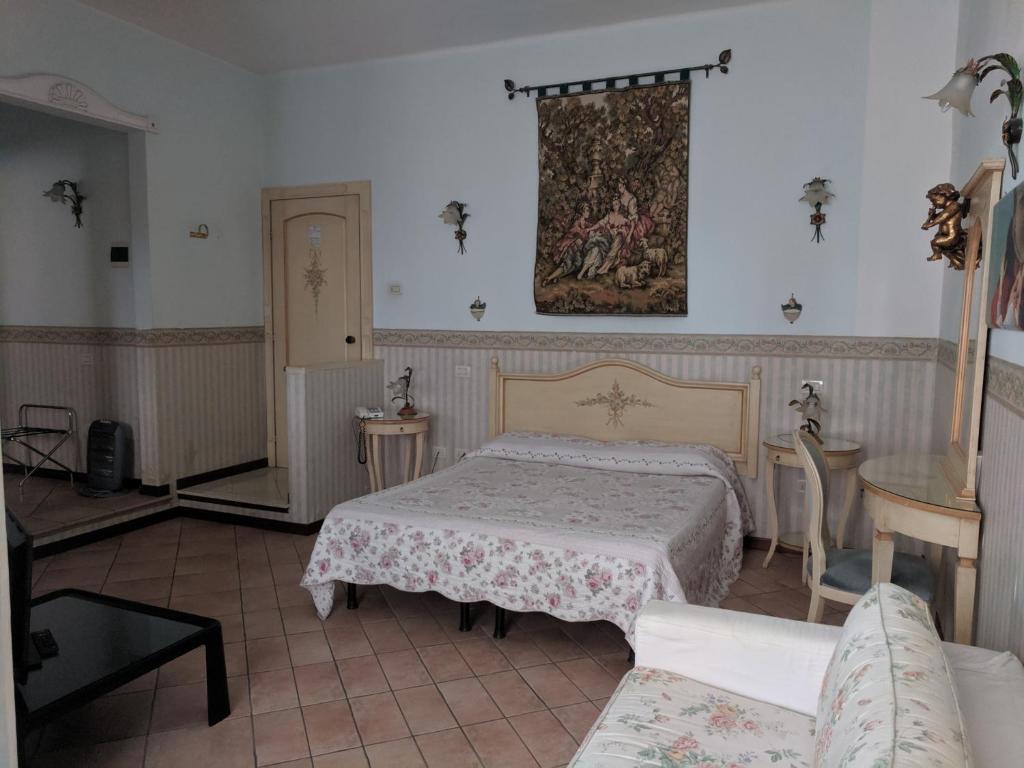 a room with a bed, table, and a painting on the wall at D'Elite Room & Breakfast in Ferrara