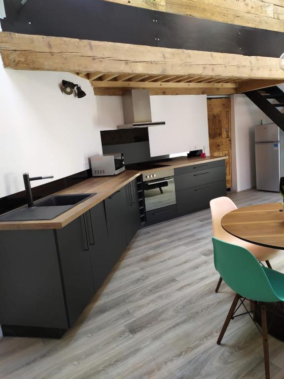 una cucina con armadi neri e soffitto in legno di Wine Loft 66 a Baixas