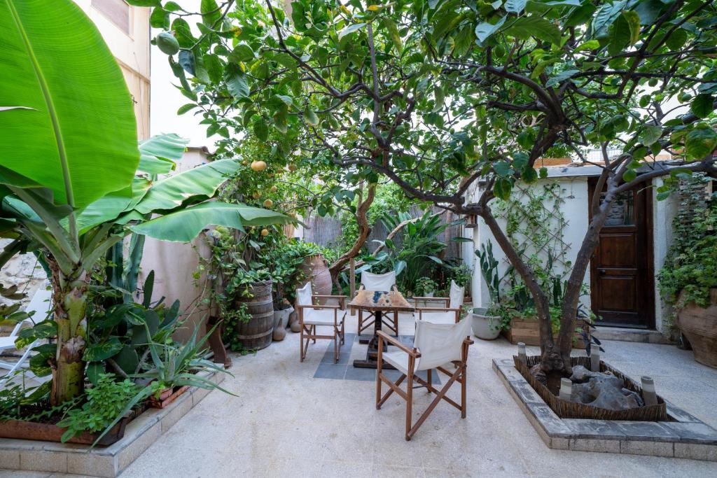 a patio with a table and chairs under a tree at Lemon Garden Residence in Heraklio