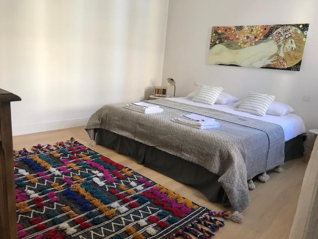 - une chambre avec un lit doté d'une couverture et d'un tapis dans l'établissement Le Nid Perché - Montpellier Centre, à Montpellier