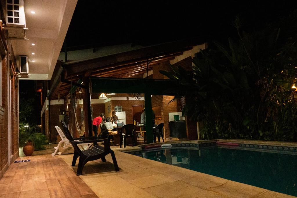 a house with a swimming pool at night at Managua Apart Hotel in Puerto Iguazú