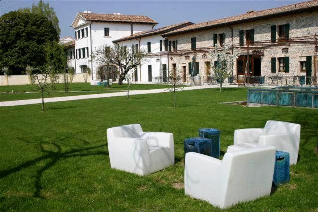un grupo de sillas blancas sentadas en el césped en Agriturismo Fossa Mala, en Fiume Veneto
