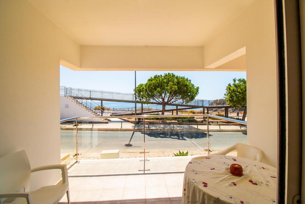 een kamer met een tafel en uitzicht op de oceaan bij Apt Baleeira Sol in Albufeira