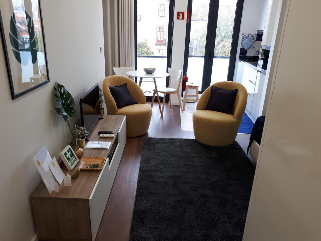 een woonkamer met 2 stoelen en een tafel bij 4PortoApartments#4 in Porto