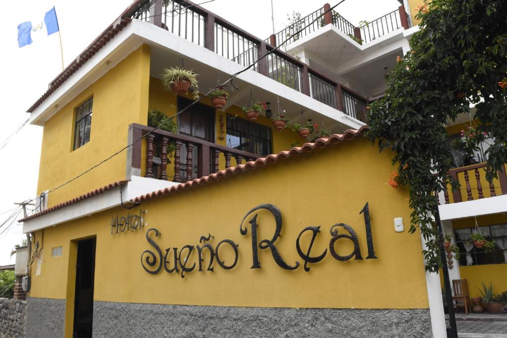 un edificio amarillo con el nombre de un restaurante en Hotel Sueño Real, en Panajachel