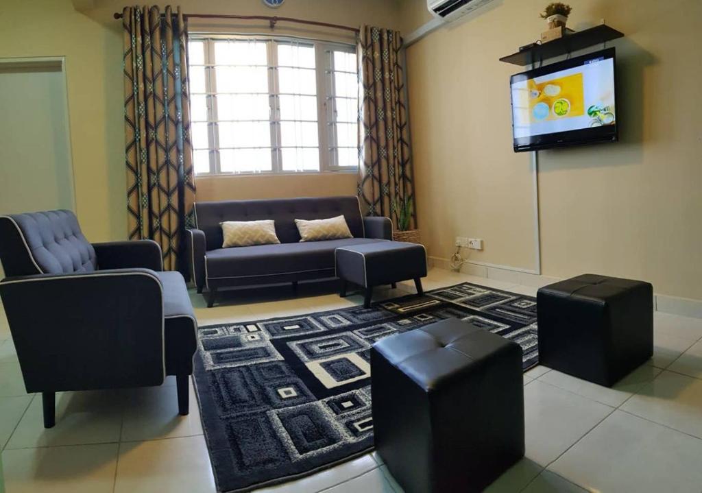 sala de estar con sofá y TV de pantalla plana en DinDas Family Stay @ Labuan, en Labuan