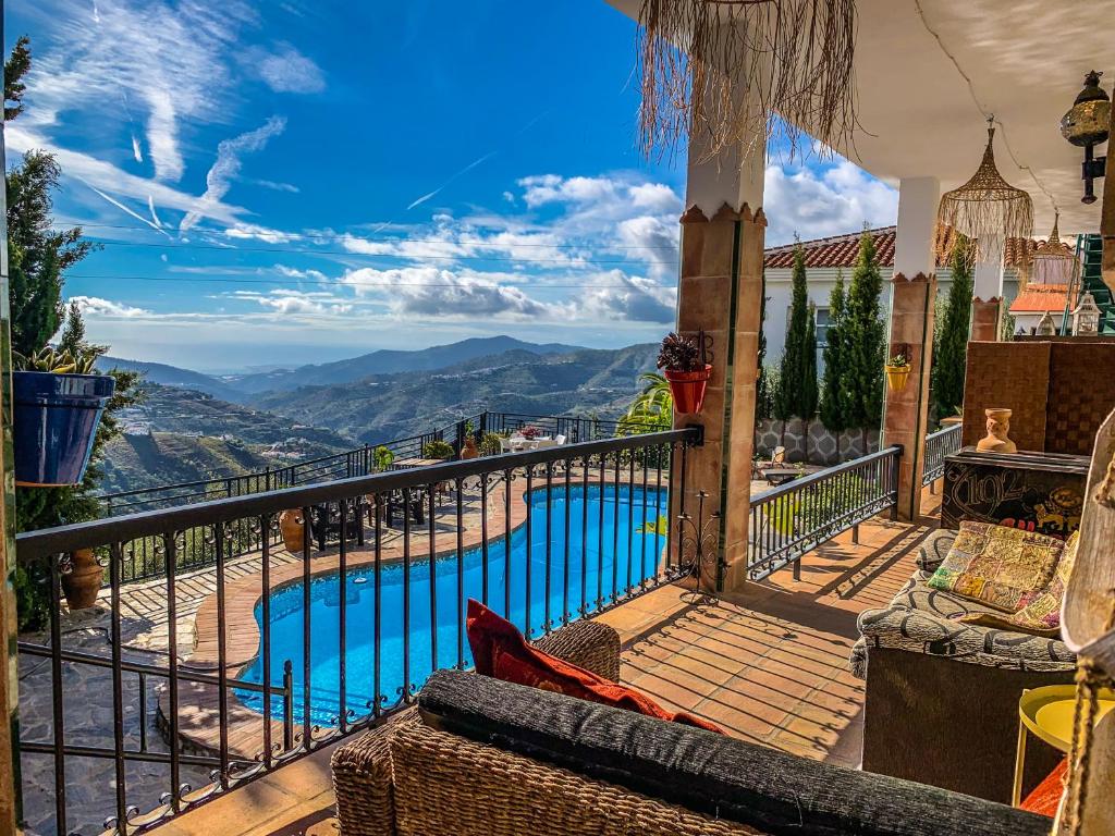 uma varanda com vista para uma piscina em Apartamentos Alma y Montaña em Cómpeta