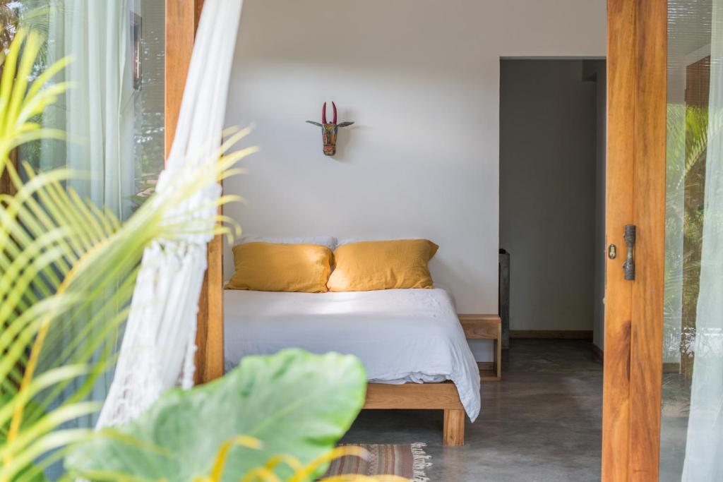 1 dormitorio con 1 cama y 1 cruz en la pared en Lucero, en Santa Teresa Beach