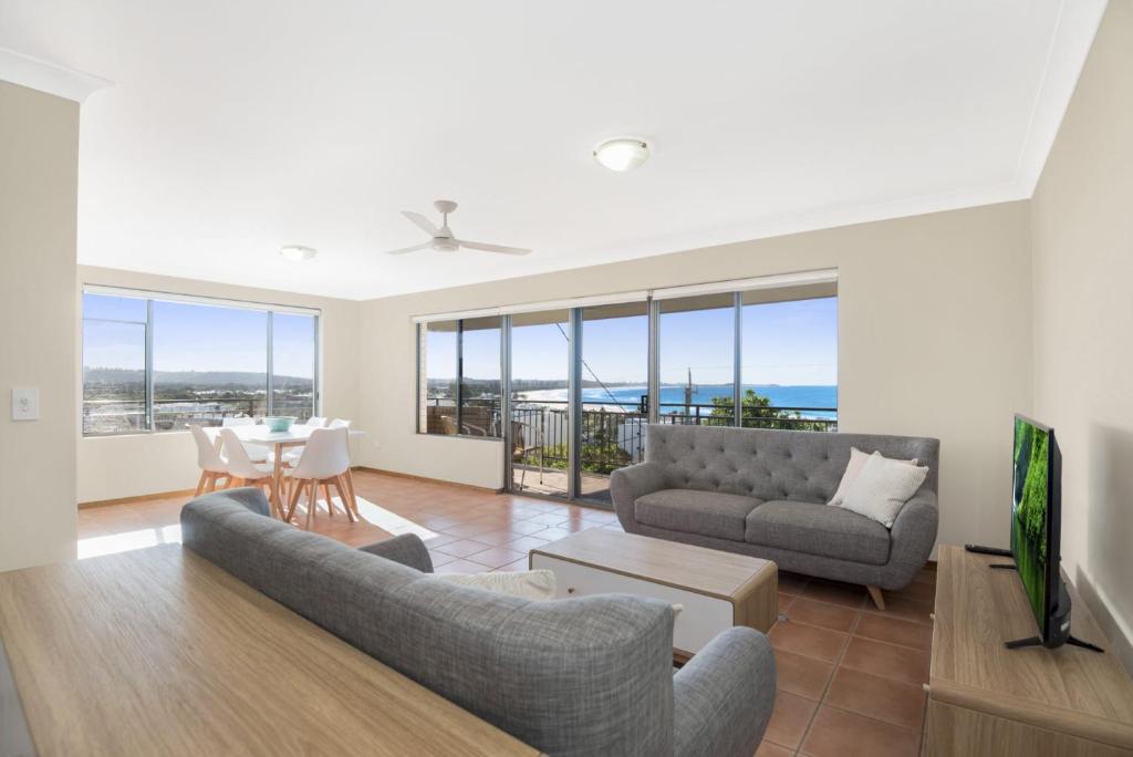 a living room with a couch and a table with chairs at Sea Gaze Apartments by Kingscliff Accommodation in Kingscliff