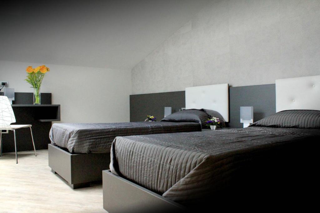 a bedroom with two beds and a table with flowers at Giulimà B&B in Rocchetta SantʼAntonio