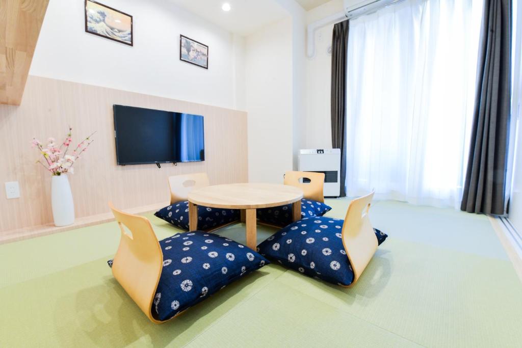 a living room with a table and some pillows at momo premium 603 in Sapporo