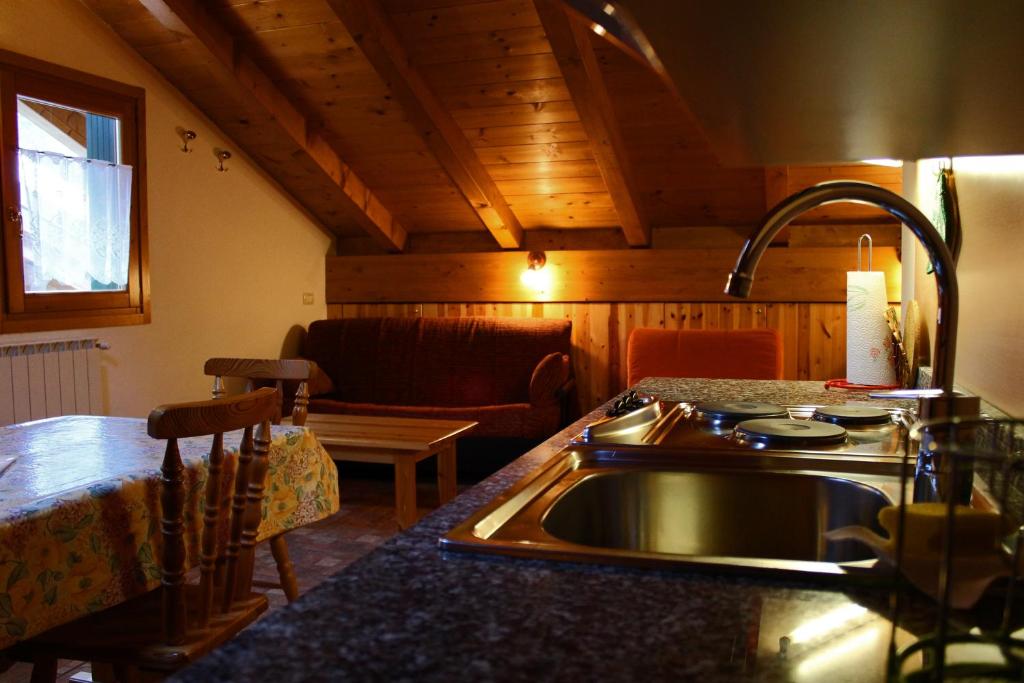 a kitchen with a sink and a table in a room at Chalet Presanella in Temù