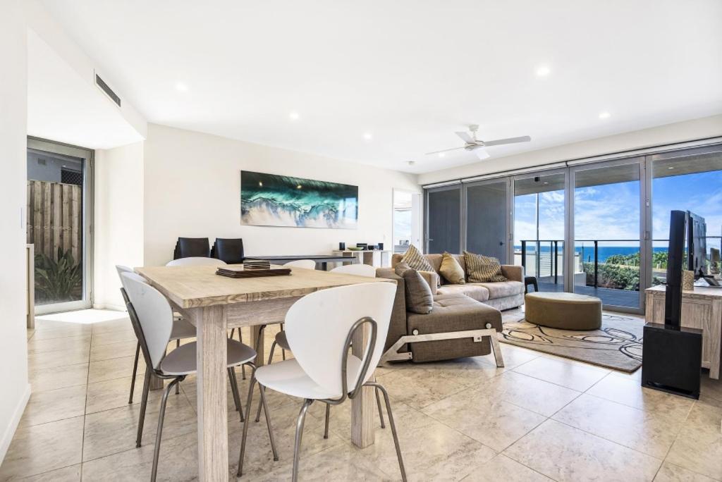 a living room with a table and chairs and a couch at Beachfront Cabarita Apartment by Kingscliff Accommodation in Cabarita Beach