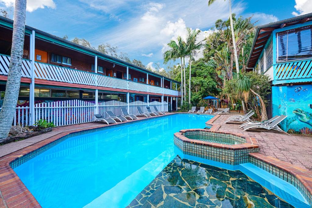 a swimming pool in front of a building at Arts Factory Lodge in Byron Bay