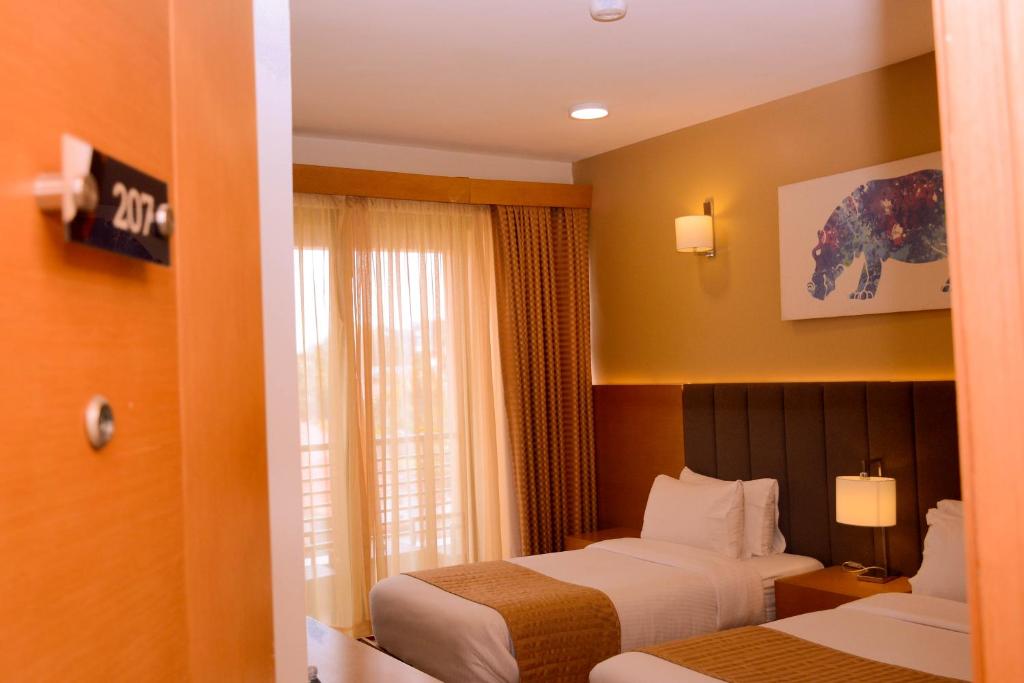 Een bed of bedden in een kamer bij K Hotels Entebbe