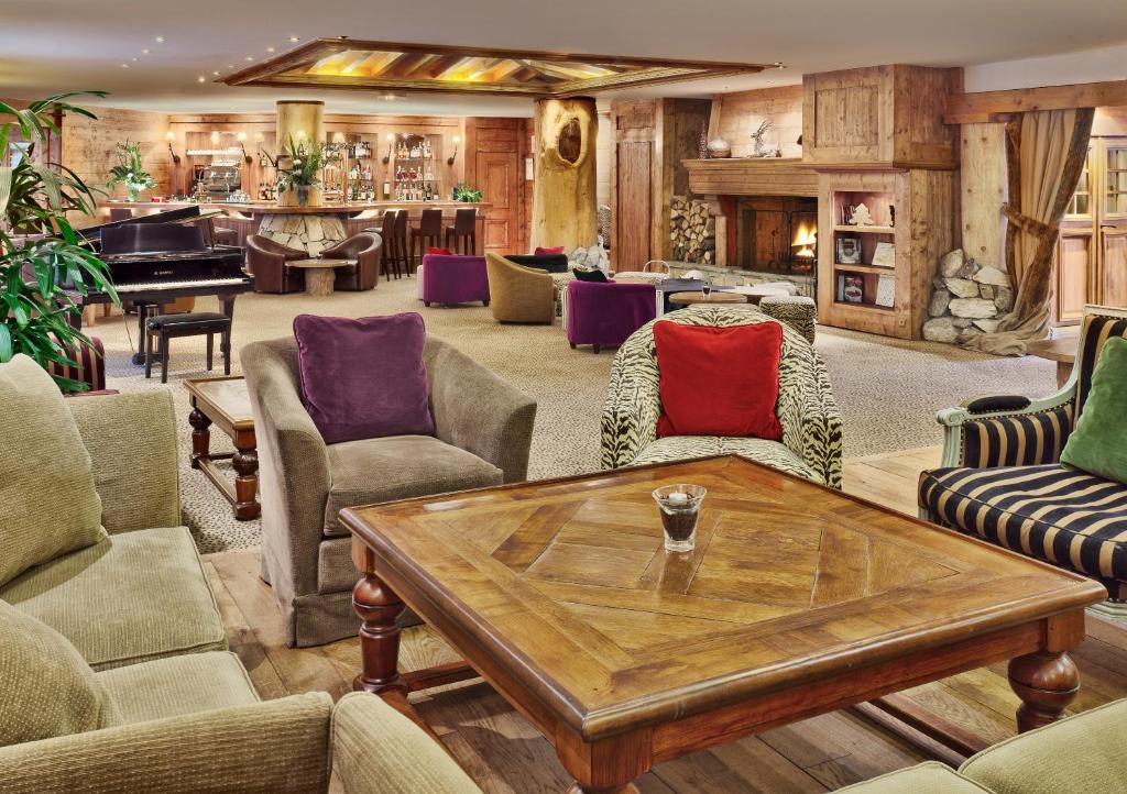 a living room with a table and a piano at Hôtel Les Barmes De l'Ours in Val-d'Isère