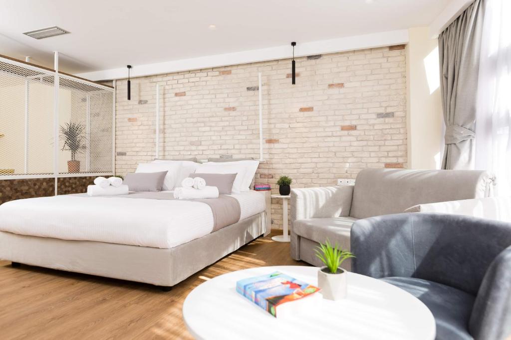 un salon avec deux lits et un canapé dans l'établissement SUITES@SYNGROU-FIX, à Athènes