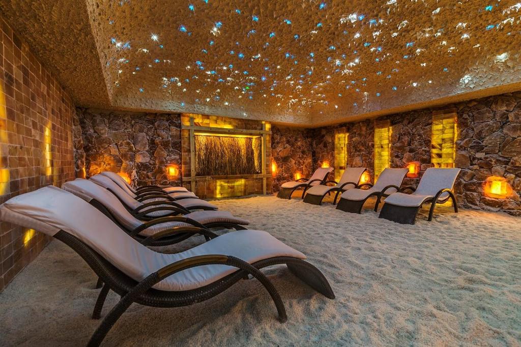 a row of chairs in a room with a stone wall at Grand Lubicz Uzdrowisko Ustka in Ustka