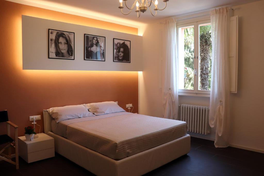 a bedroom with a bed with pictures on the wall at Locanda Dolcevita in Dozza
