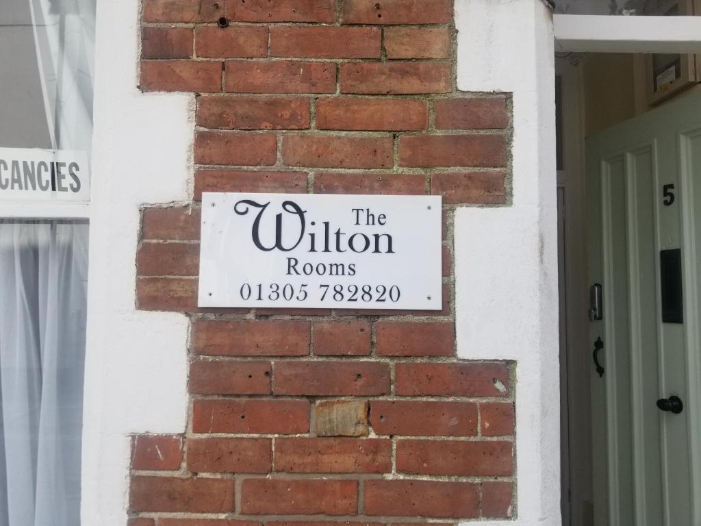 a sign for the wilson rooms on a brick wall at The Wilton Weymouth in Weymouth