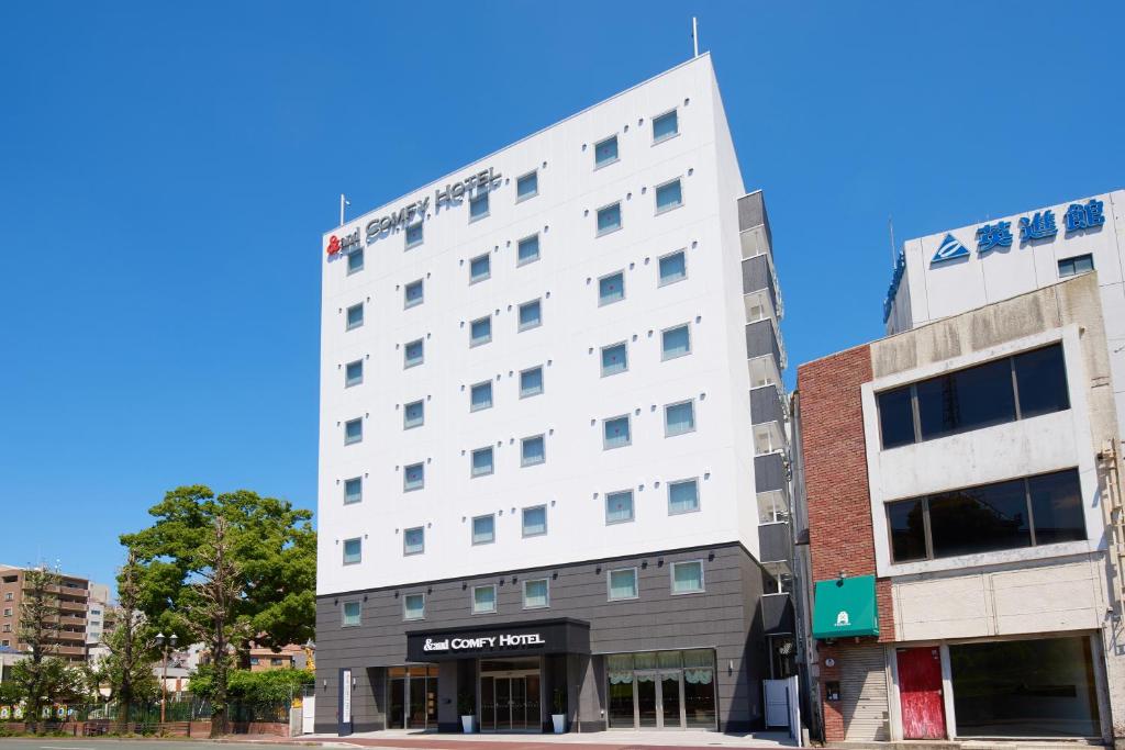 a white building on the corner of a street at &and COMFY HOTEL Kumamoto Jo View in Kumamoto