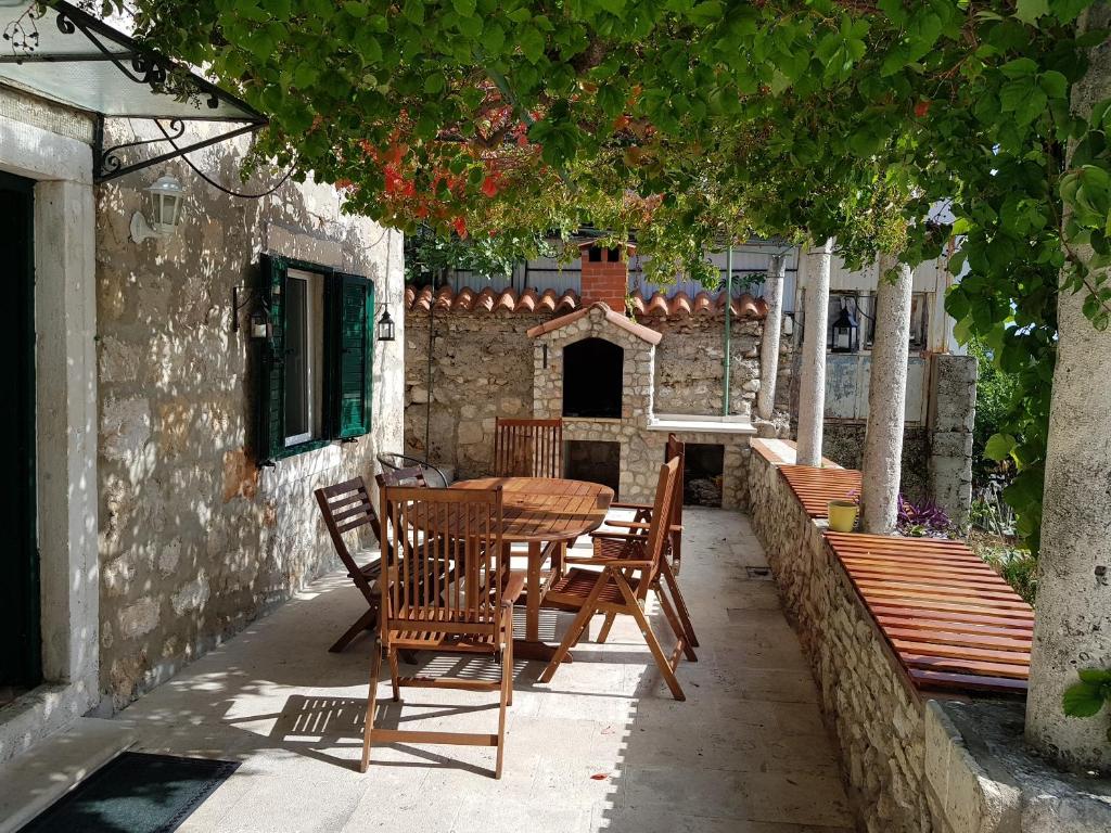 una mesa de madera y sillas en un patio en Apartment Dubrava, en Dubrovnik