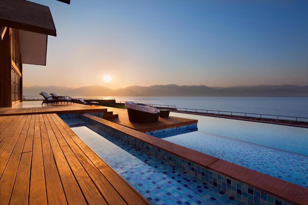 een zwembad met uitzicht op het water bij Herbert Samuel Royal Shangri-La Eilat in Eilat