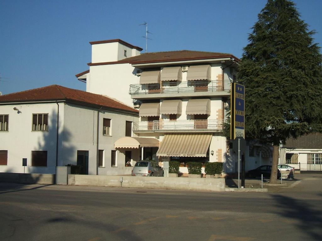 a large white building with balconies on a street at Hotel Ristorante Da Gianni in Bovolone