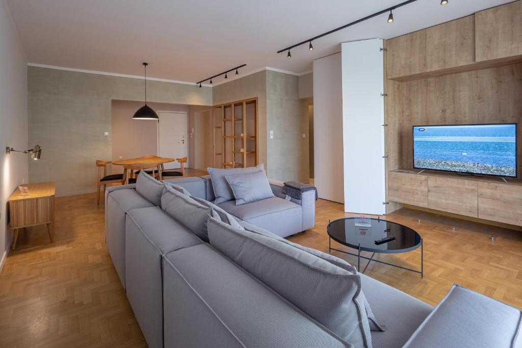 a living room with a couch and a tv at Hippocrates - Faliro deluxe apartment in Athens