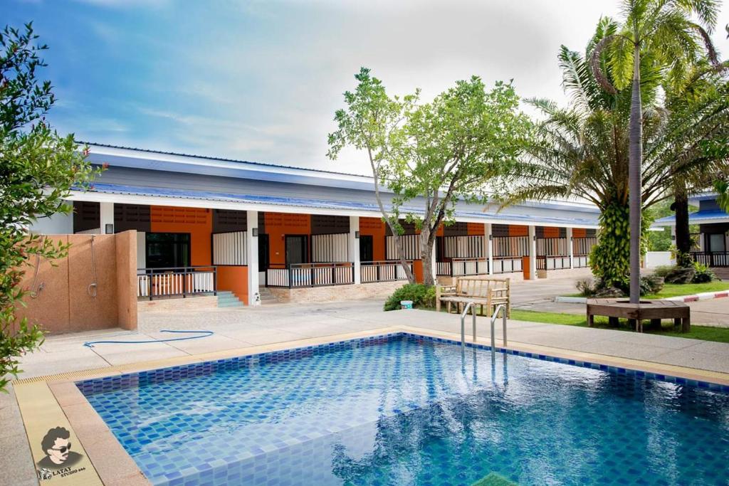 a swimming pool in front of a building at Staychill Resort in Uttaradit