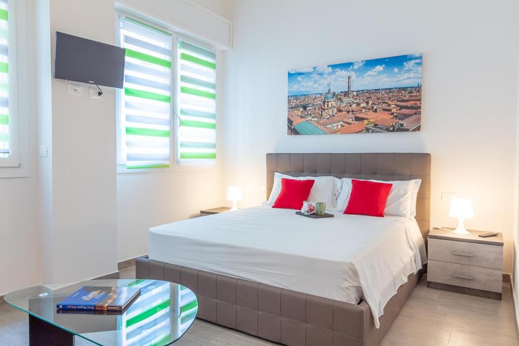 um quarto com uma cama grande e almofadas vermelhas em Realkasa Azzarita Flat em Bolonha