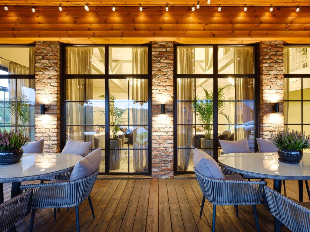 un restaurante con mesas y sillas en una terraza de madera en 5 stories, en Inkartai