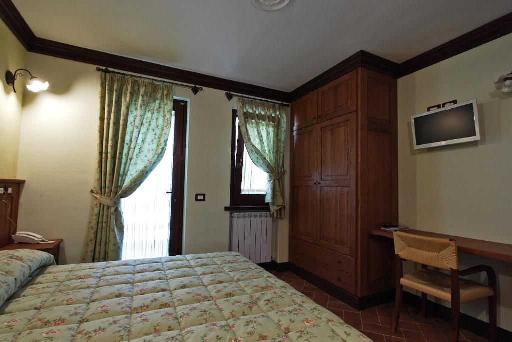 sypialnia z łóżkiem, biurkiem i oknem w obiekcie B&B IL PINO w mieście Pescocostanzo