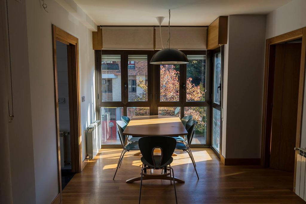 a dining room with a table and chairs and a window at Bidasoa by Basquelidays in Irún