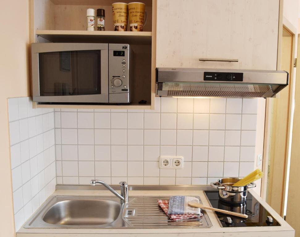 cocina con fregadero y microondas en Mikro Apartments Erding en Erding