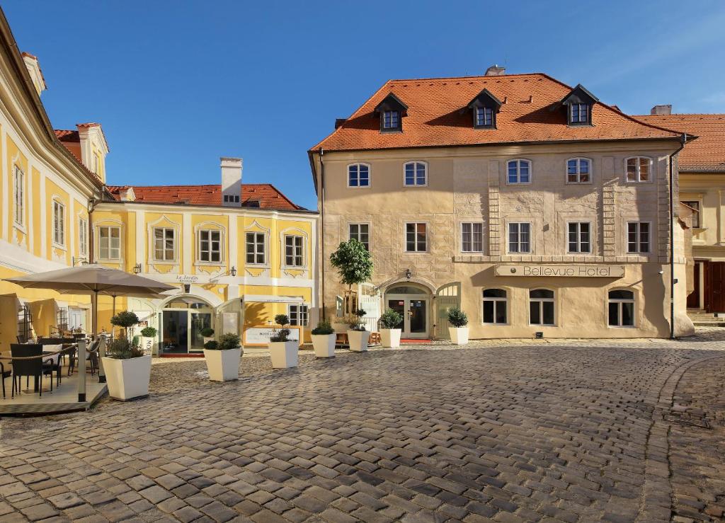 a cobblestone street in a town with buildings at Bellevue Hotel Český Krumlov in Český Krumlov